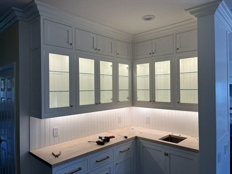 Cabinetry with illuminated glass fronts and counter lighting