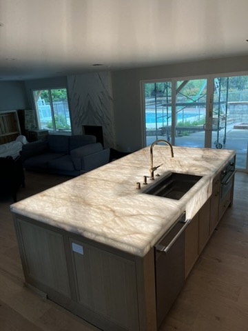 Kitchen island with pendant lighting and illuminated work surfaces